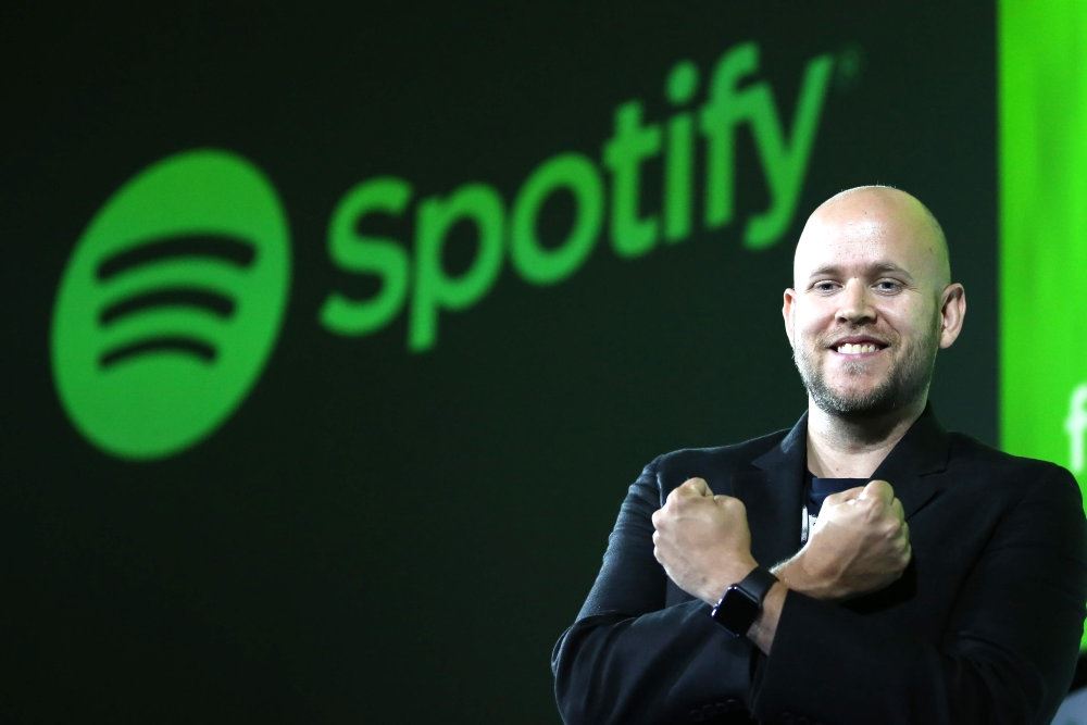 En glad mand foran Spotify-logo