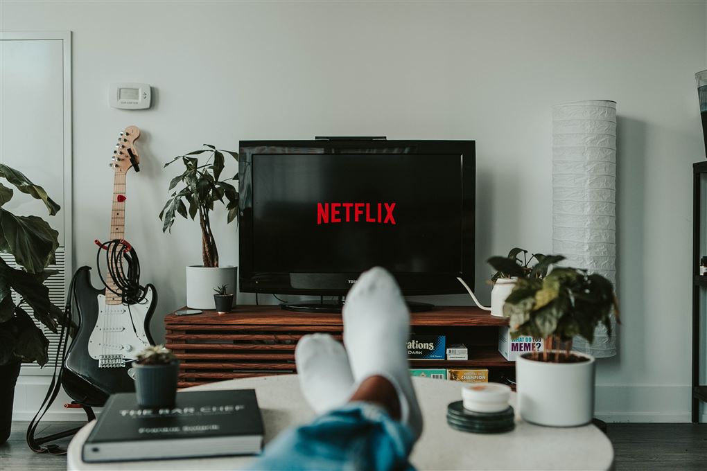 En skærm med Netflix og en fyr med benen op på skrivebordet