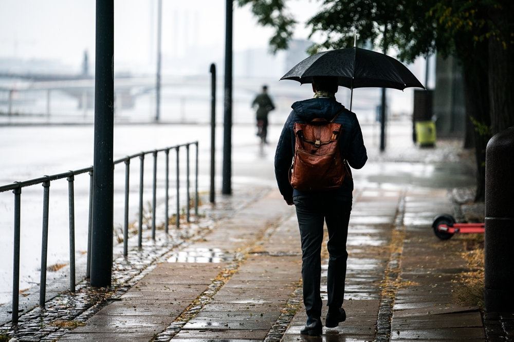 mand går med paraply i regnvejr