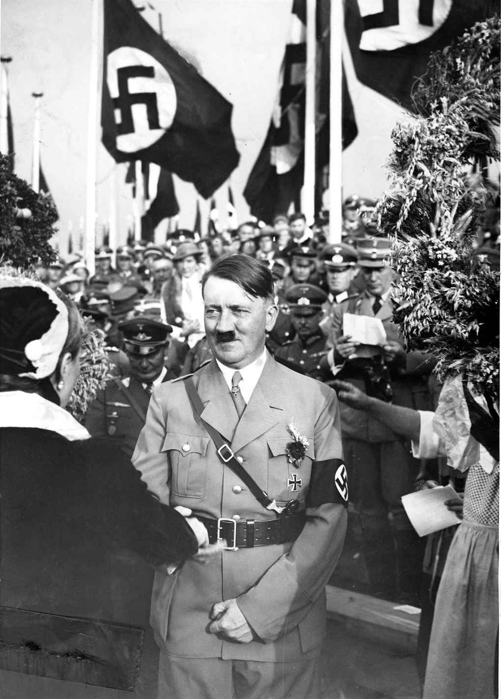 Adolf Hitler smiler smørret under det velkendte lille overskæg. 
