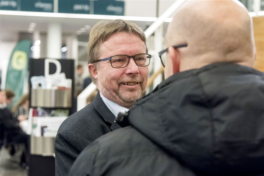 Politiker Niels Dueholm hilser på en mand med et smil. 