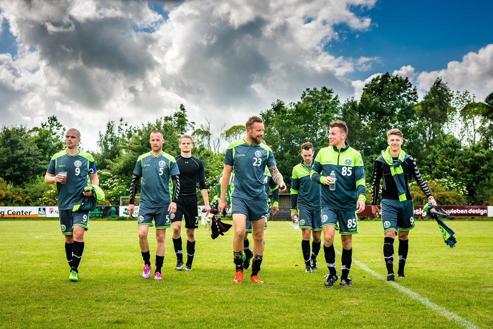 fodboldspillere går på fodboldbane 