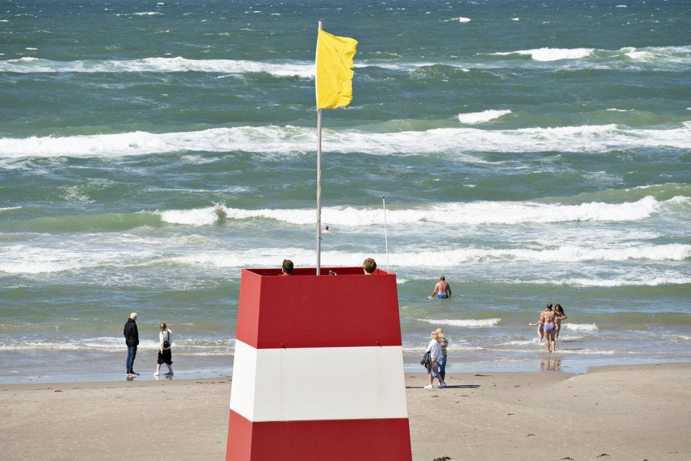 Et livreddertårn med gult flag på en strand
