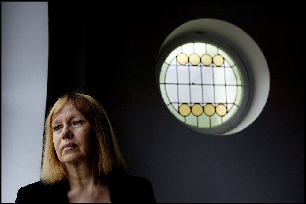 En rødhåret dame ved et rundt vindue