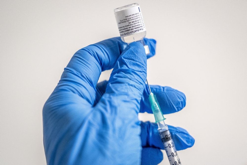 vaccine trækkes ud af glas med sprøjte