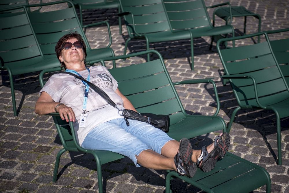 kvinde med solbriller slapper af på bænk 