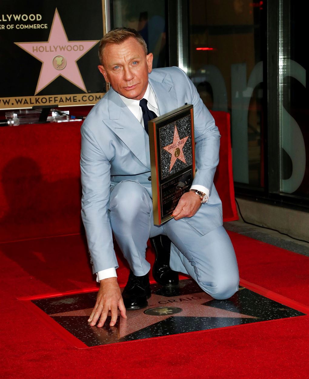 En mand i lyseblåt jakkesæt med en stjerne skilt i hånden