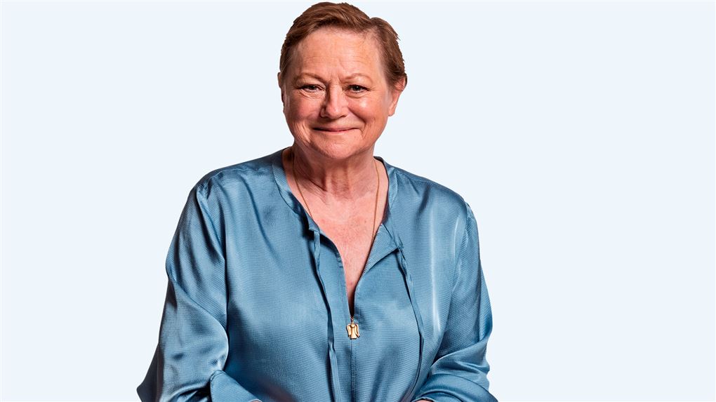 Pressebillede af Lisbet Dahl i lyseblå satinbluse og smil.