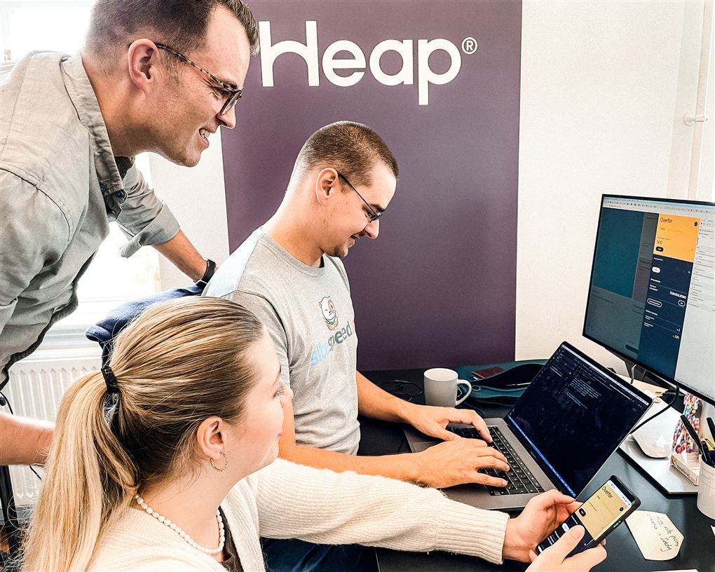 Tre mennesker omkring en computer