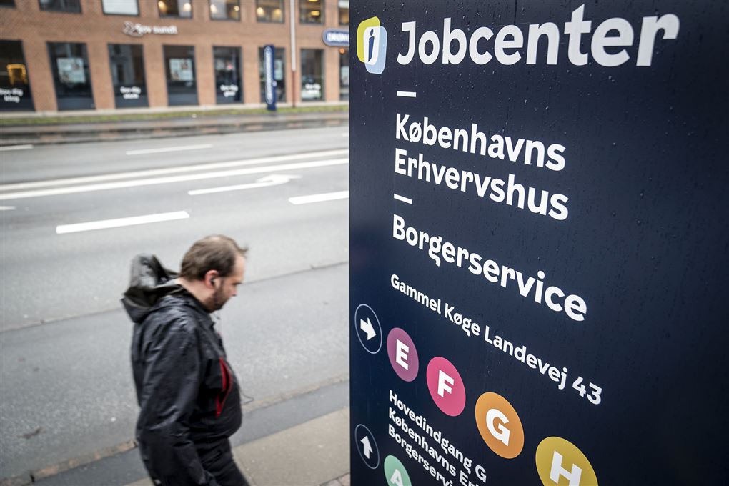 En mand går forbi Jobcenter-skilt