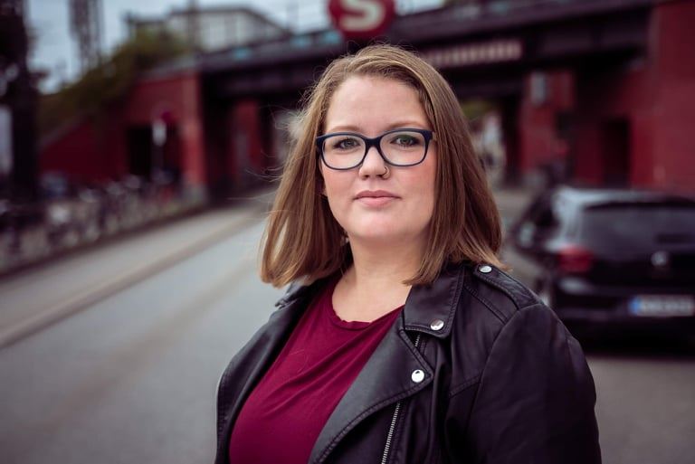 En dame med briller og brunt glat hår
