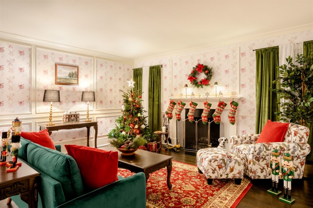 Husets stue med pejs hvor der hænger en masse julesokker. Ved siden af står et pyntet juletræ.