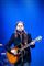 Tim Christensen på scenen med sin guitar og blå baggrund.