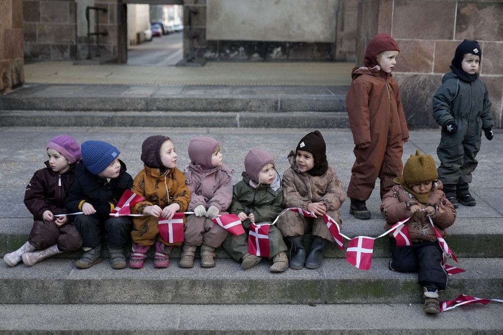 små børn sidder med flag