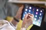 person sidder med tablet 