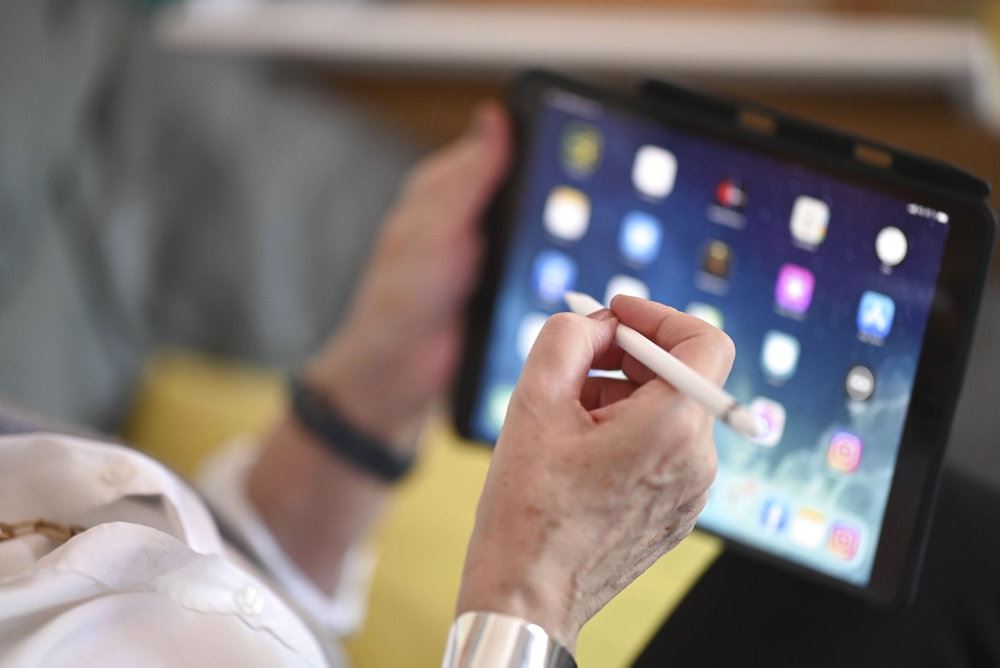 person sidder med tablet 