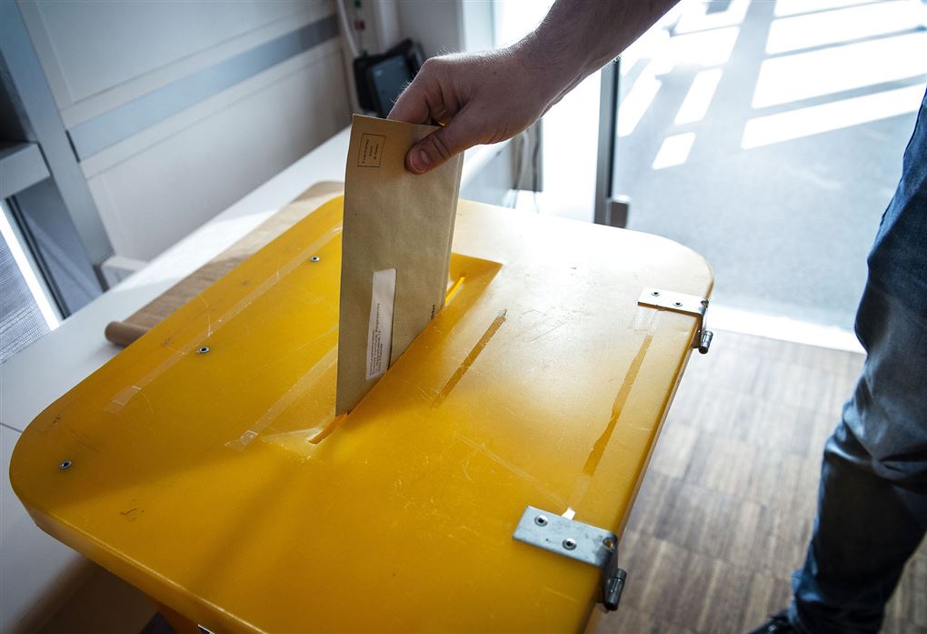 person putter stemmeseddel i kasse