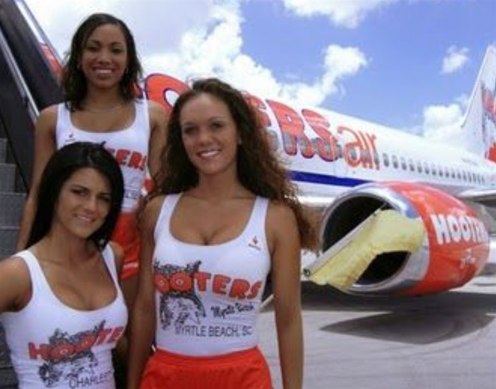 3 letpåklædet damer ved et fly