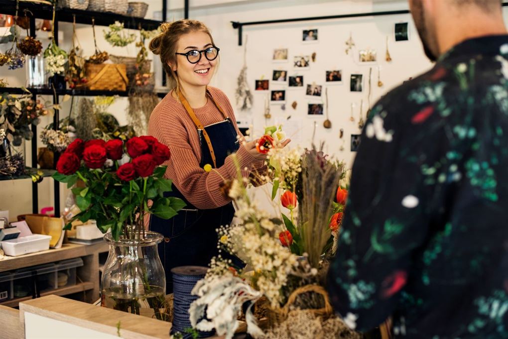 blomsterhandler står i butik