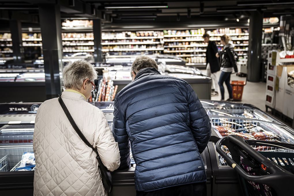 Et par kigger ned i en fryser i et supermarked