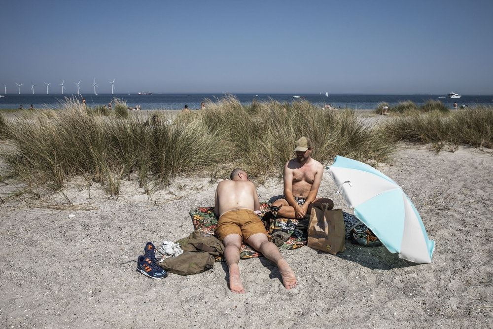 folk ligger og solbader på strand