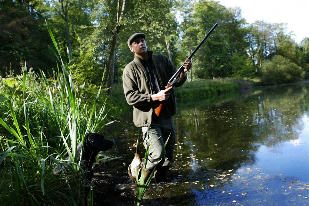En jæger i en sø med gevær