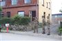Tre hjemmeværnsfolk foran en udbrændt villa. 