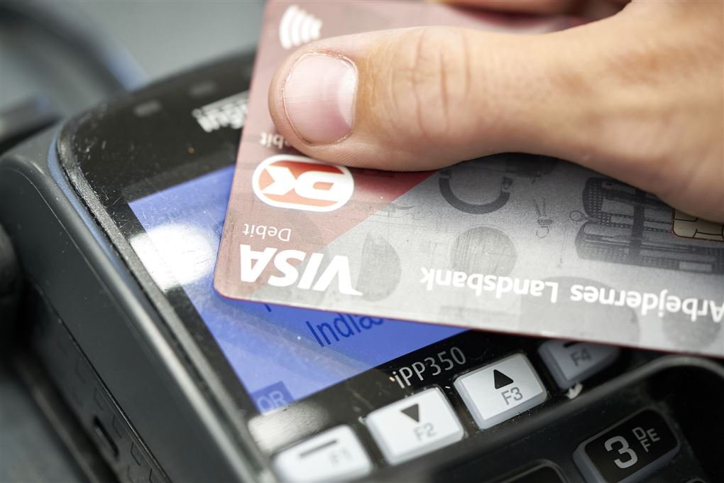 kreditkort føres hen over betalingsterminal 