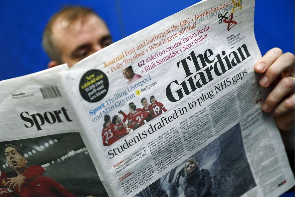 En mand læser avisen The Guardian