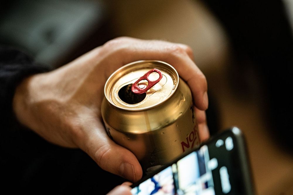 person sidder med dåseøl