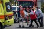 Overlevende hjælpes ind i ambulance.