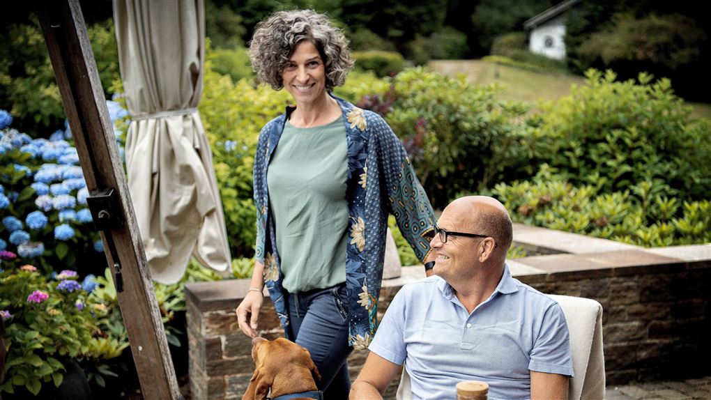 Anne Dorthe Tannerrup står bag Bjarne Riis som sidder i en stol.