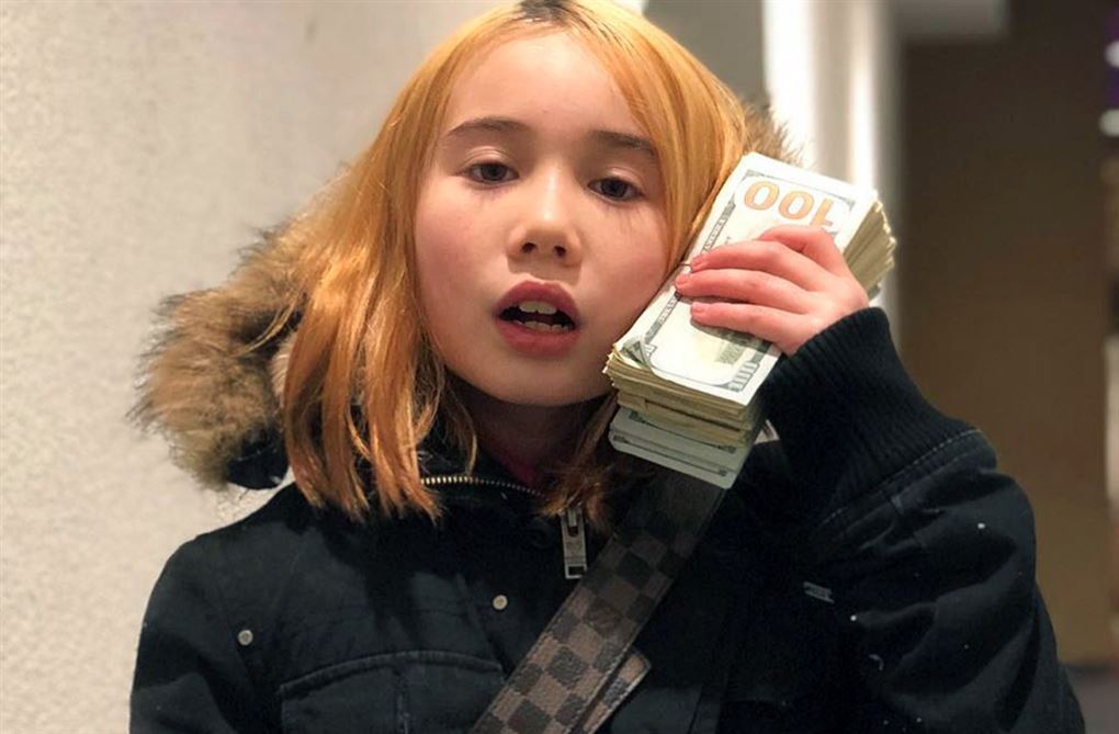 en lille pige med dollarbundt i hånden