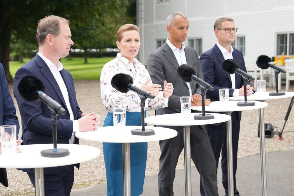 kvinde og tre mænd bag borde