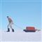 mand går på is med kuffert på slæde 
