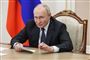 Vladimir Putin sidder i en stol og ser sur ud