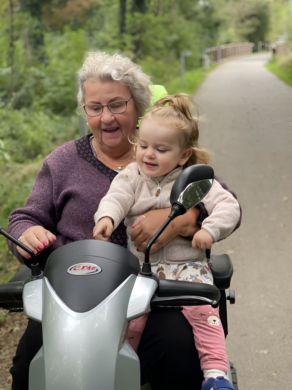 En ældre dame på en scooter.