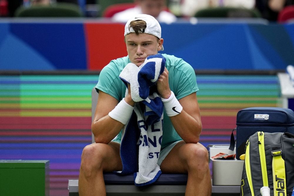 Holger Rune sidder ved tennisbanen