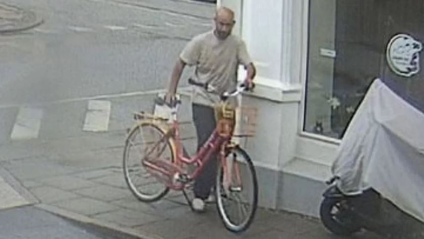 en mand trækker en cykel
