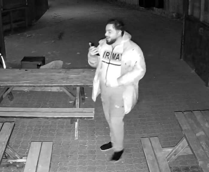 En tyk mand med en mobiltelefon i hånden