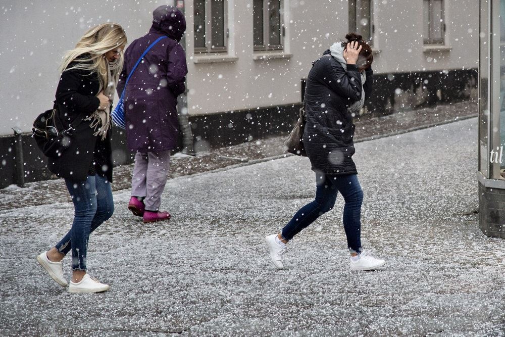 Personer på gaden i haglvejr