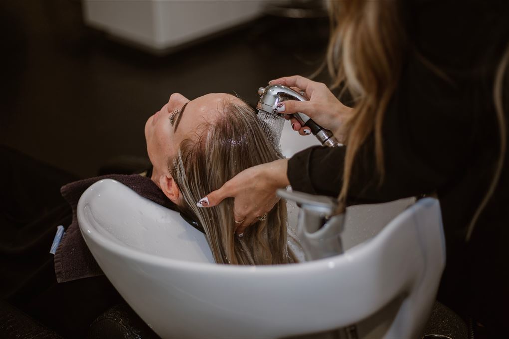 en frisør vasker hår på en person