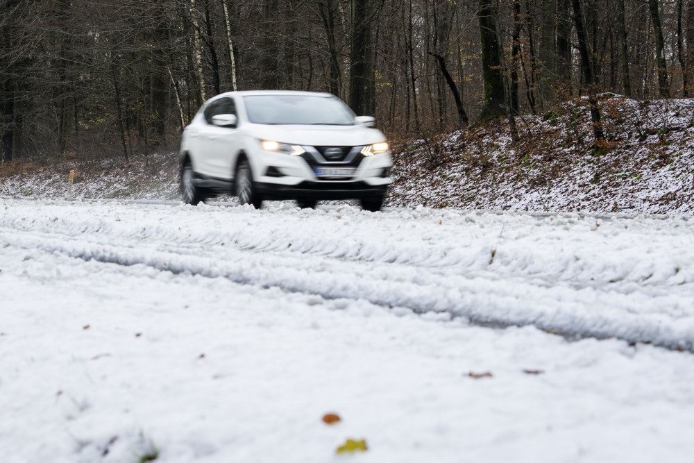 bil kører på snedækket vej