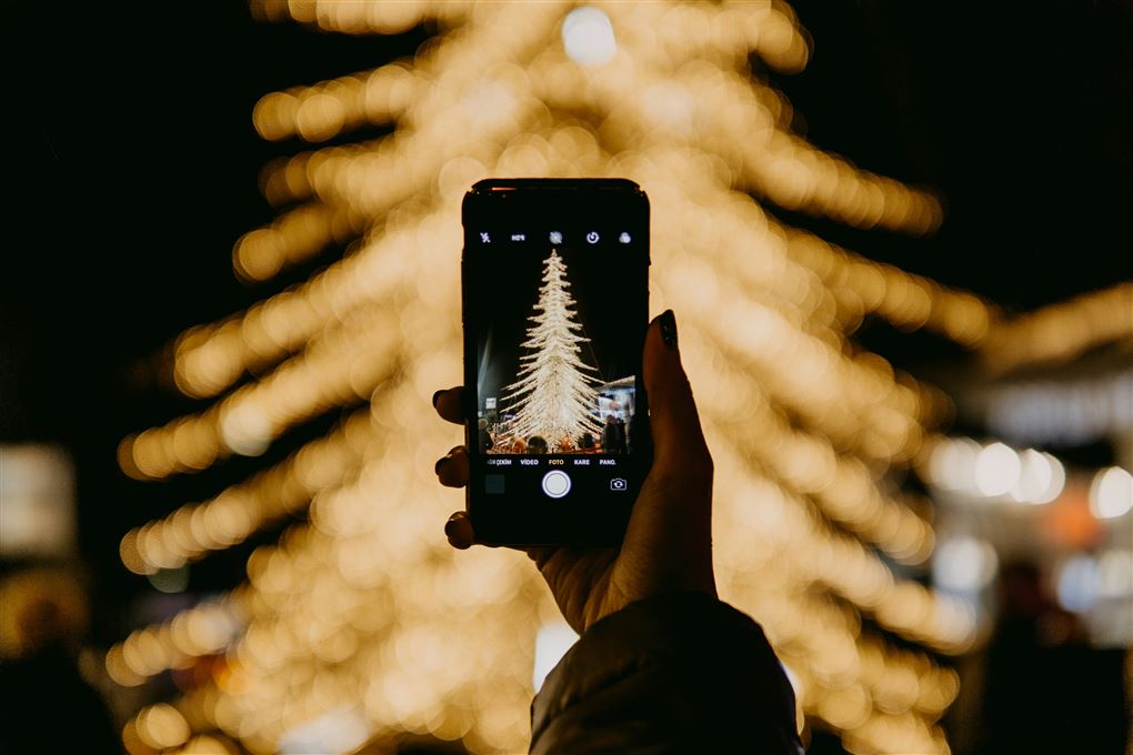 mobiltelefon foran juletræ 