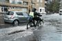 En person trækker en cykel igennem vandmasser
