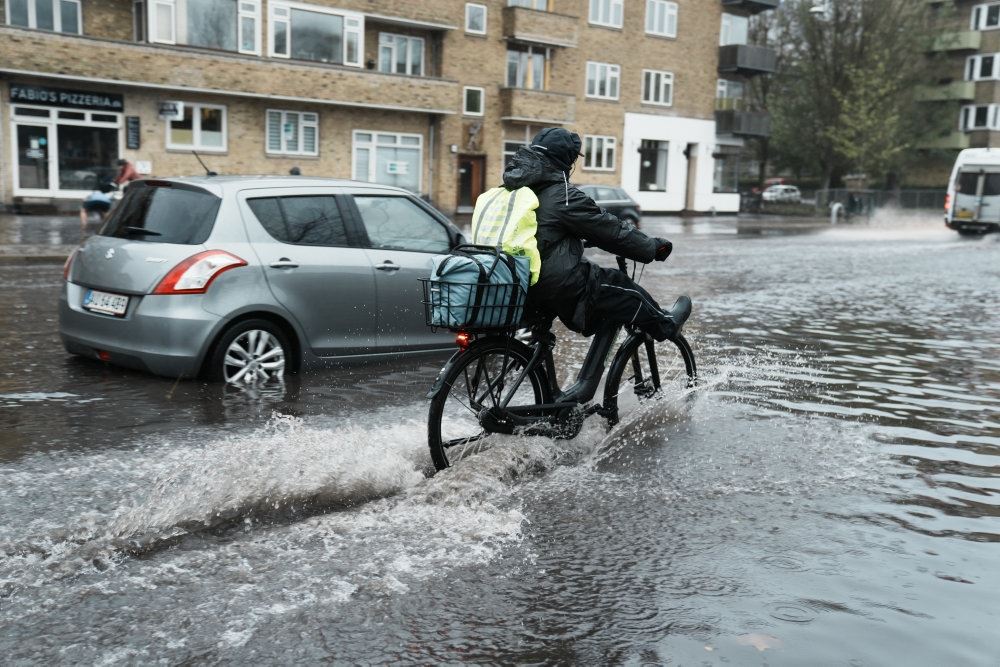 En person trækker en cykel igennem vandmasser