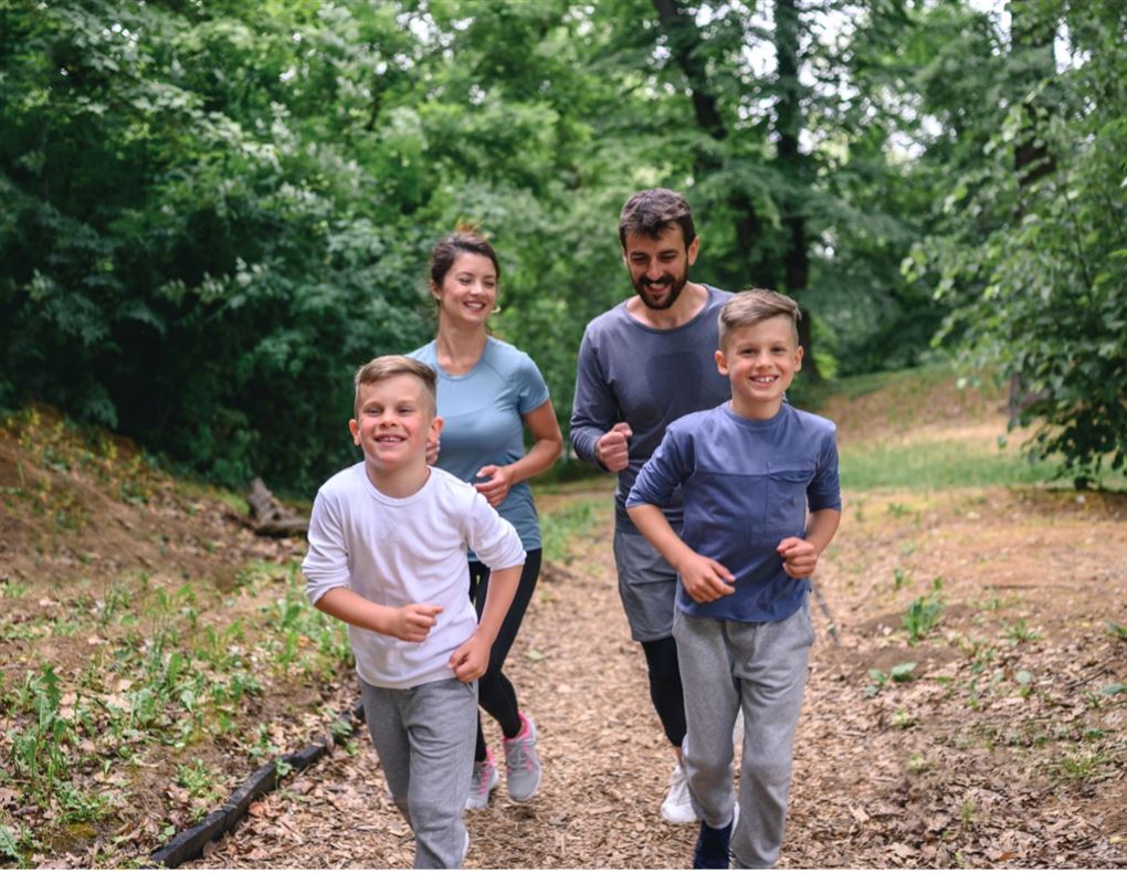 en glad familie løber i en skov