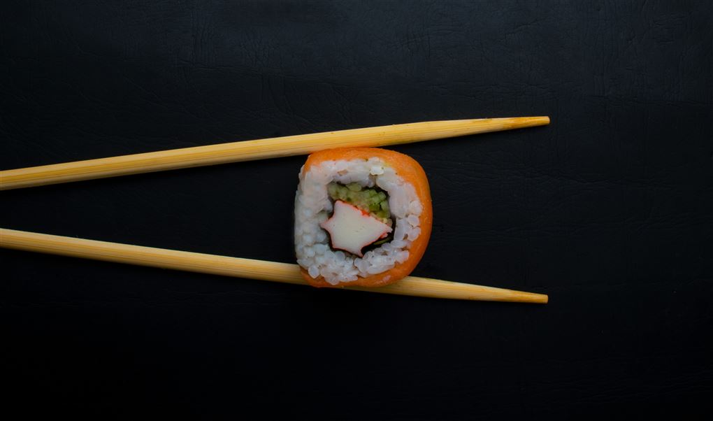 et stykke sushi mellem to spisepinde