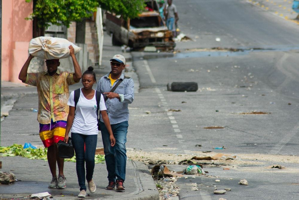 Tre personer på en gade i Haiti