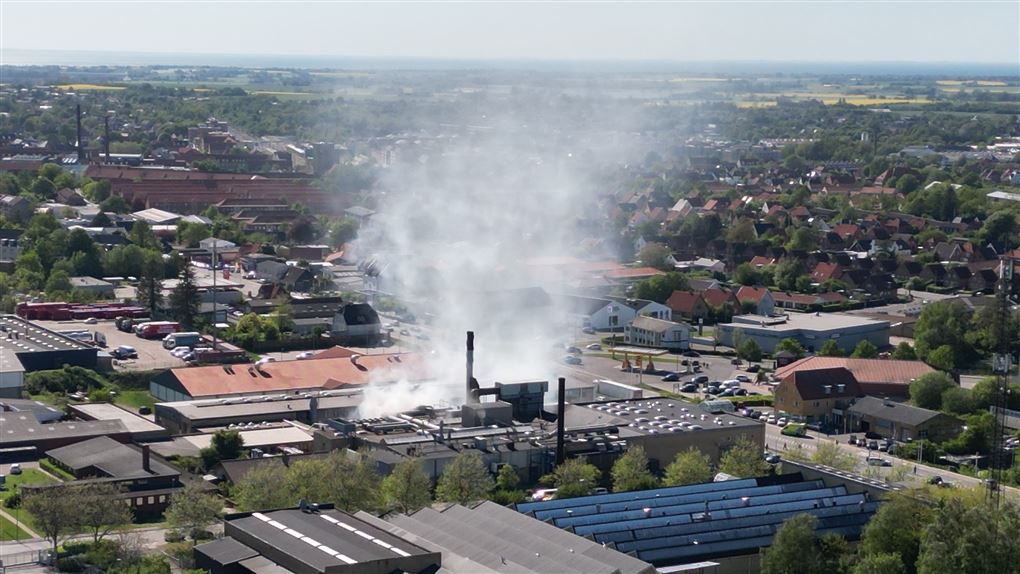 luftfoto viser røg stiger op fra bygning